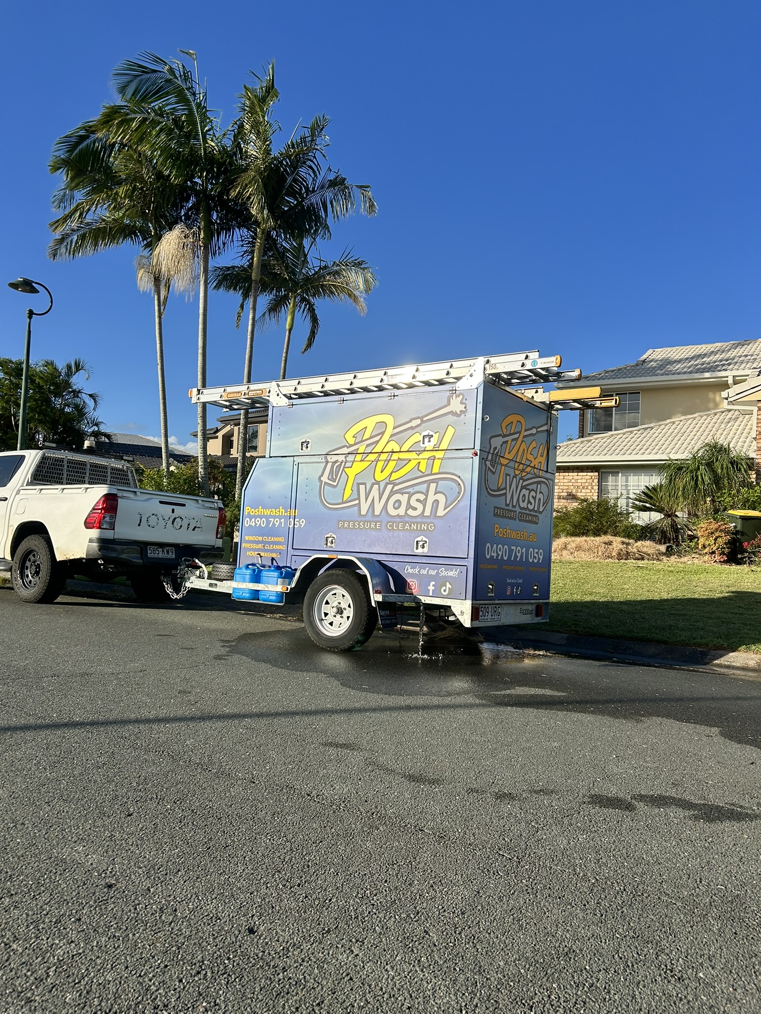 The Posh Wash branded trailer and pressure cleaning equipment set up on a Brisbane job