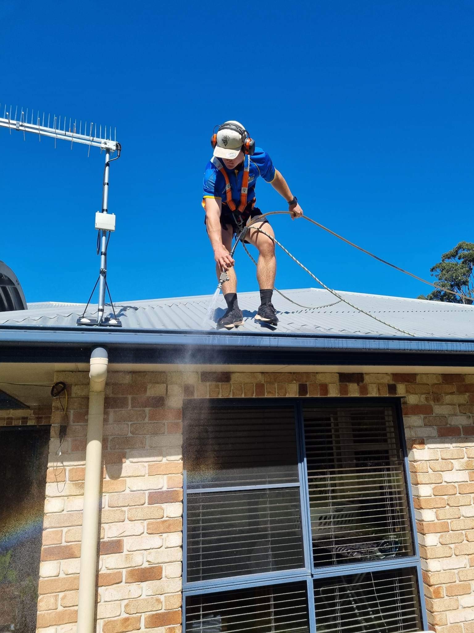 Rinsing out a cleared gutter after removing the debris