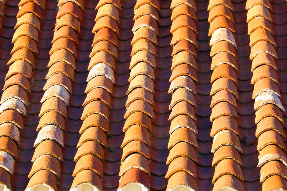 Detailed view of repetitive terracotta tiles on a roof, showcasing pattern and texture.