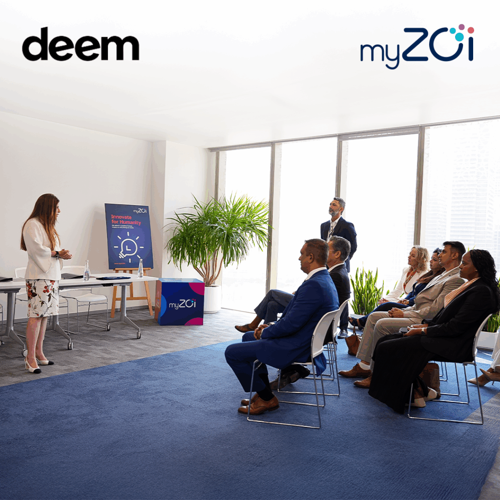 A business presentation in a modern conference room, with a speaker addressing an audience seated in chairs.