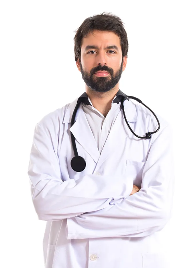 Confident male doctor with dark hair and beard wearing a white lab coat and stethoscope around his neck, arms crossed, against a white background.