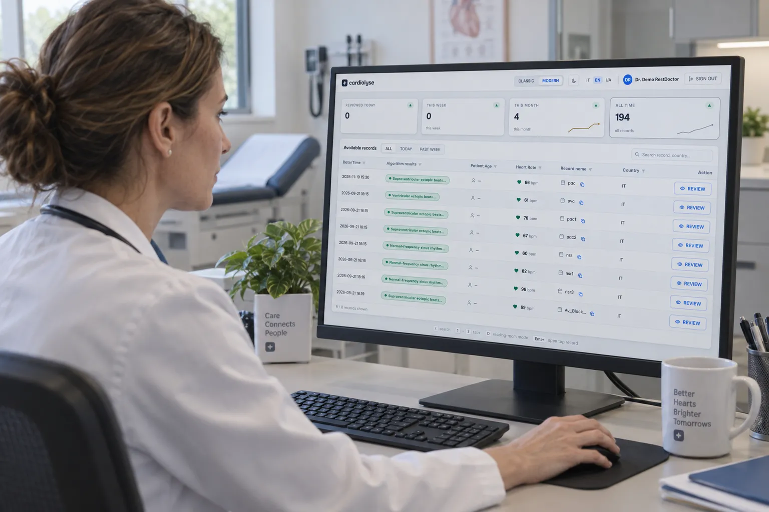 Female doctor in a white coat sits at a desk using a desktop computer displaying cardiolyse software with patient heart rate records and analysis results in a medical office.