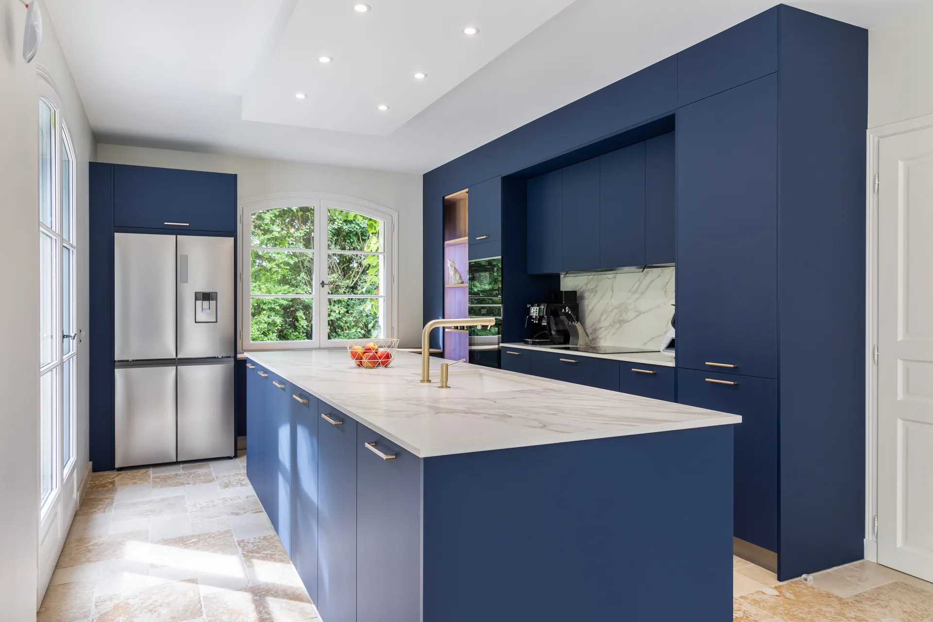 Cuisine bleue avec grand îlot central et plan de travail céramique