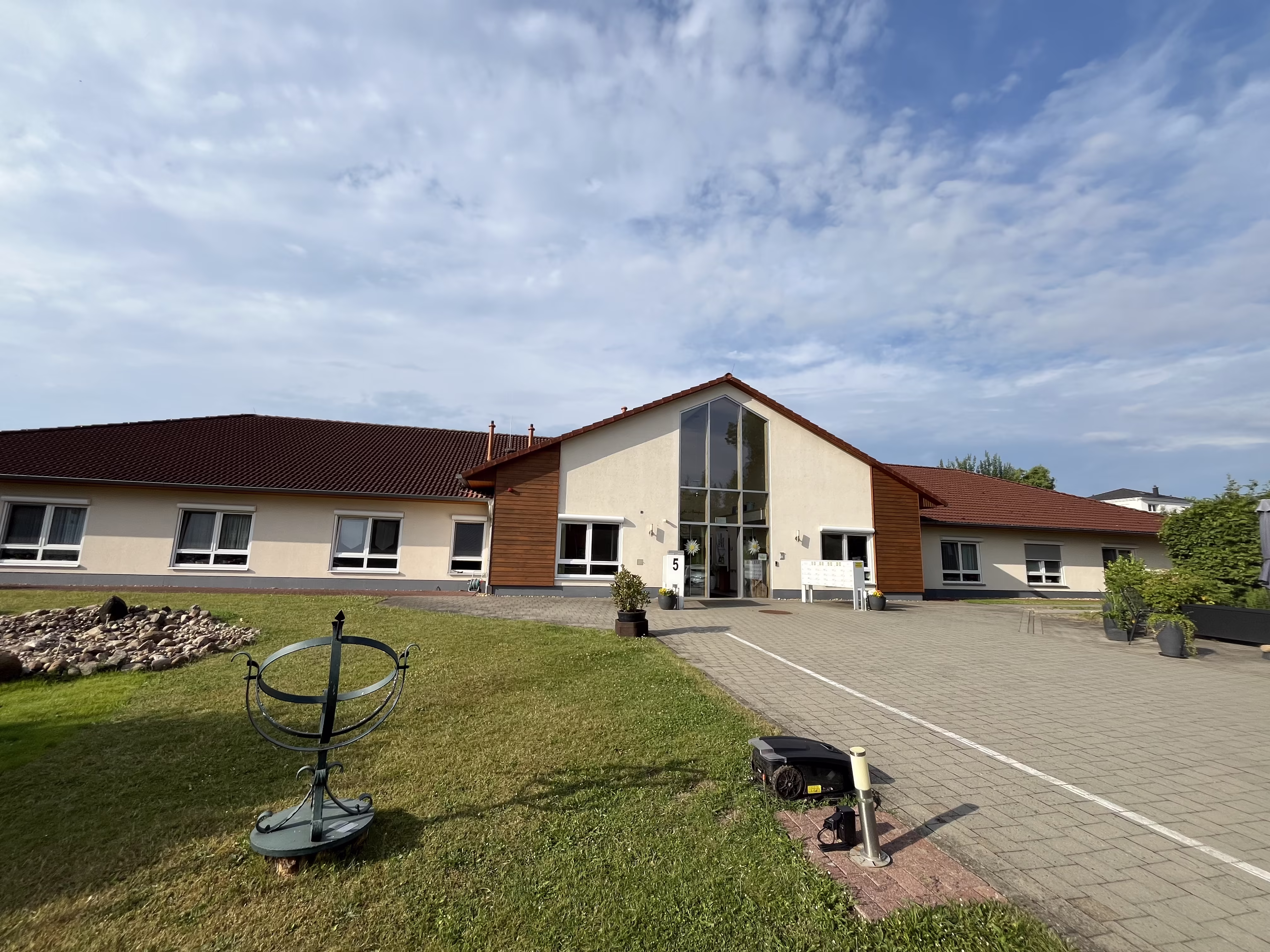 Gesamtansicht des Seniorenzentrums an der M&uuml;hle mit Rasenfl&auml;che und dem verglasten Haupteingang