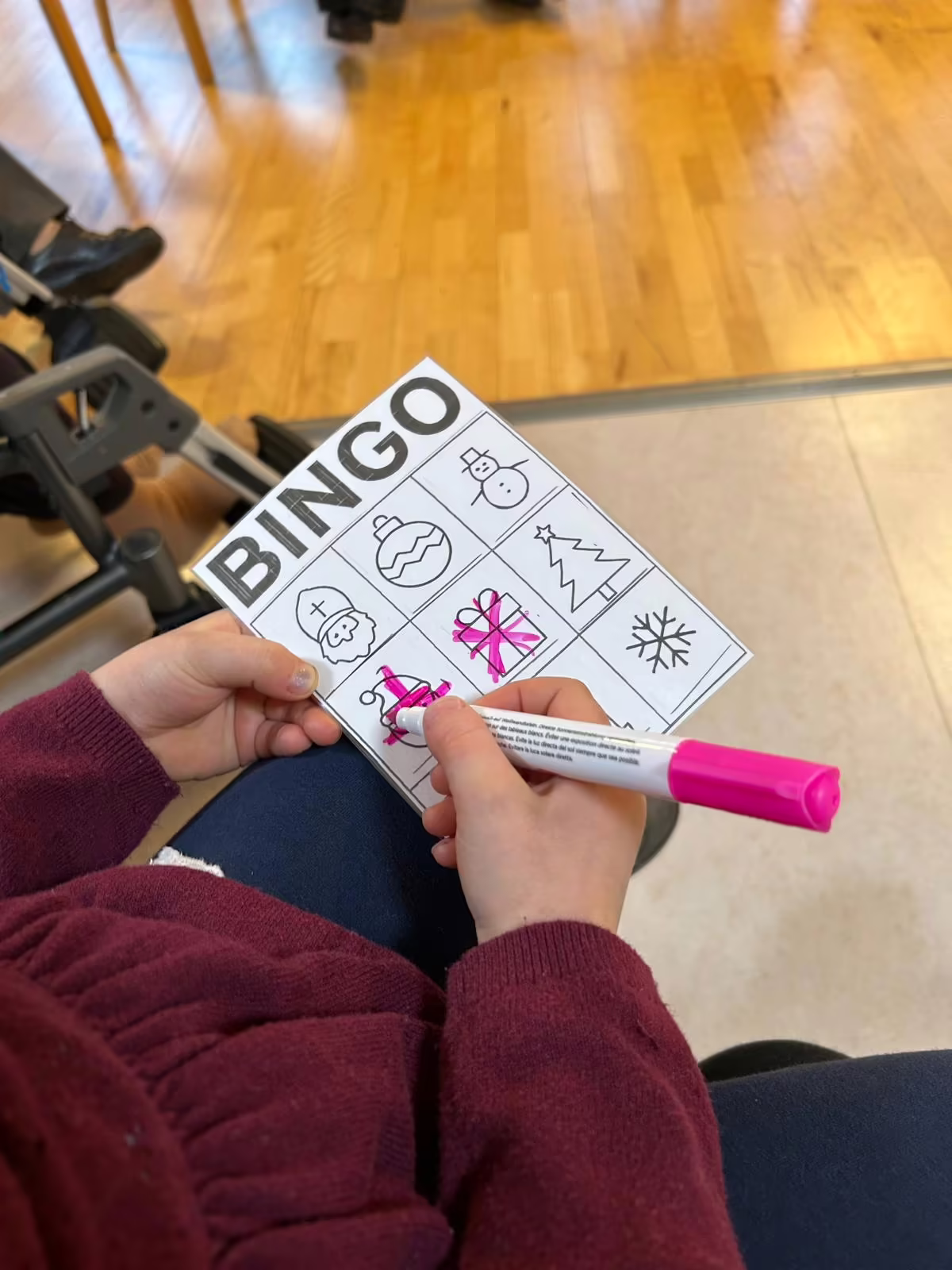 Bingo-Nachmittag im Seniorenzentrum: eine Bewohnerin markiert Felder auf ihrer weihnachtlichen Bingo-Karte