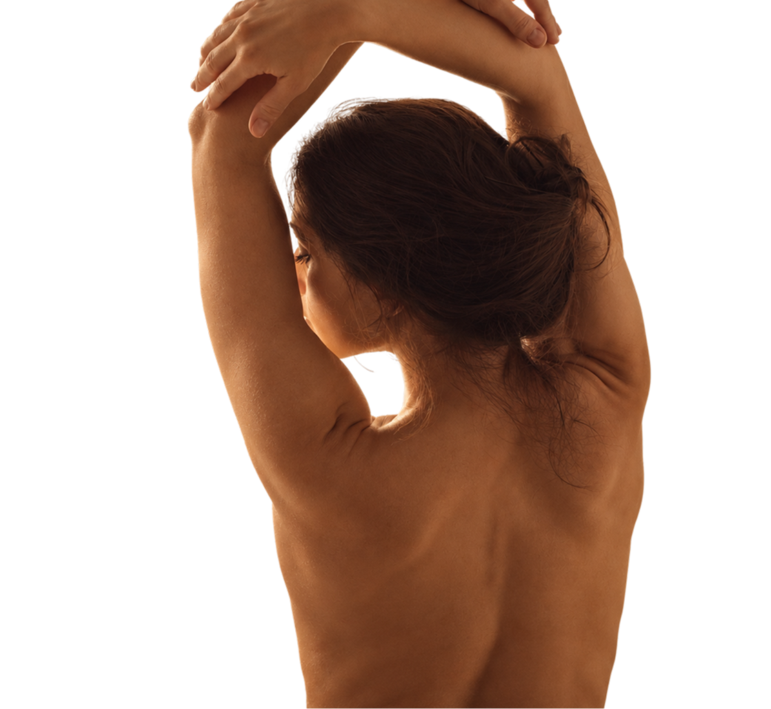 Back view of a woman with dark hair tied up, stretching her arms above her head with her hands clasped.