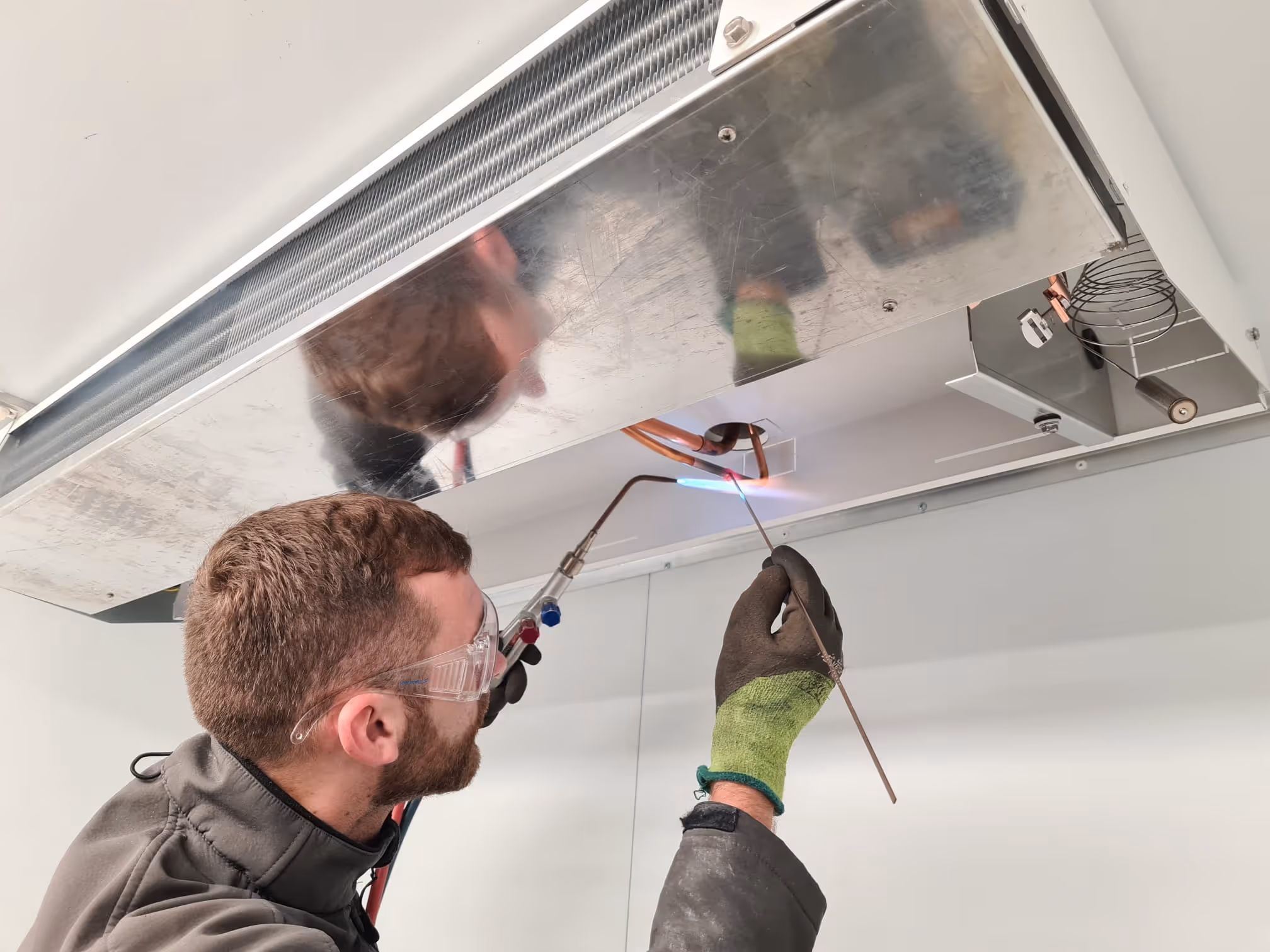 Engineer brazing refrigeration pipework during a cold-room installation