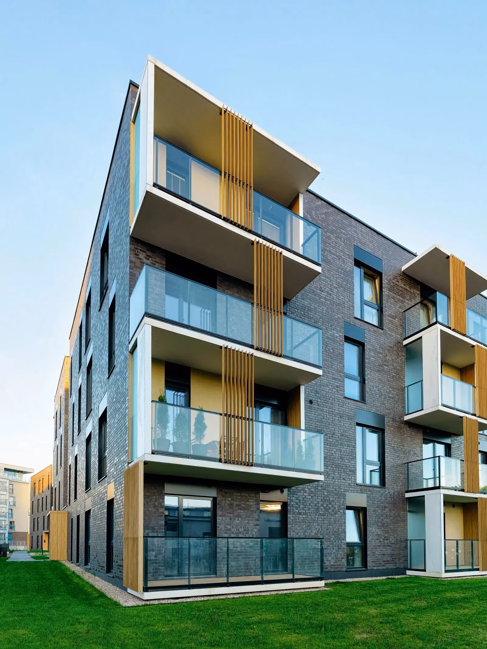 Grey brick apartment building with timber-screened balconies