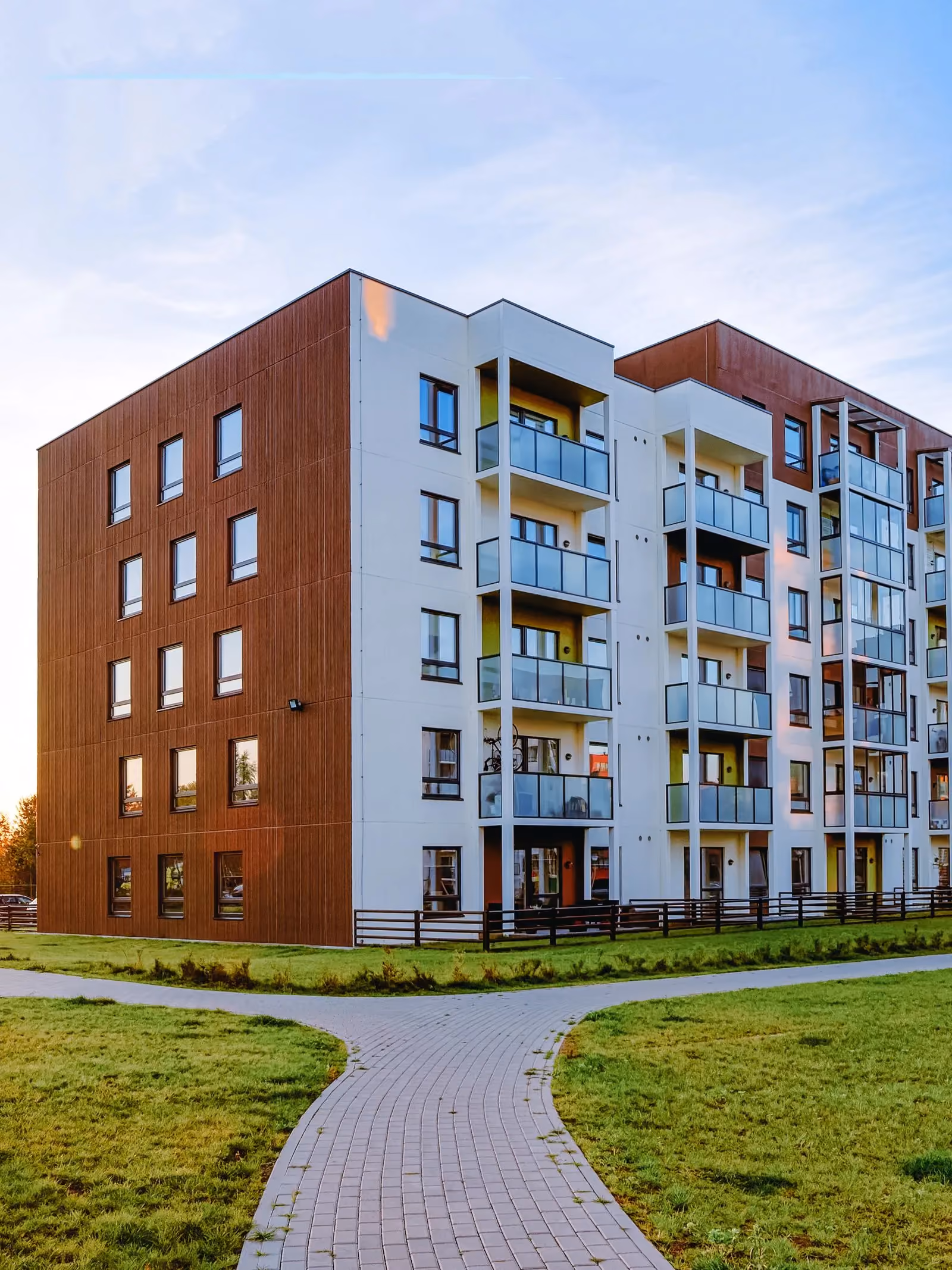Apartment building at sunset with a landscaped path