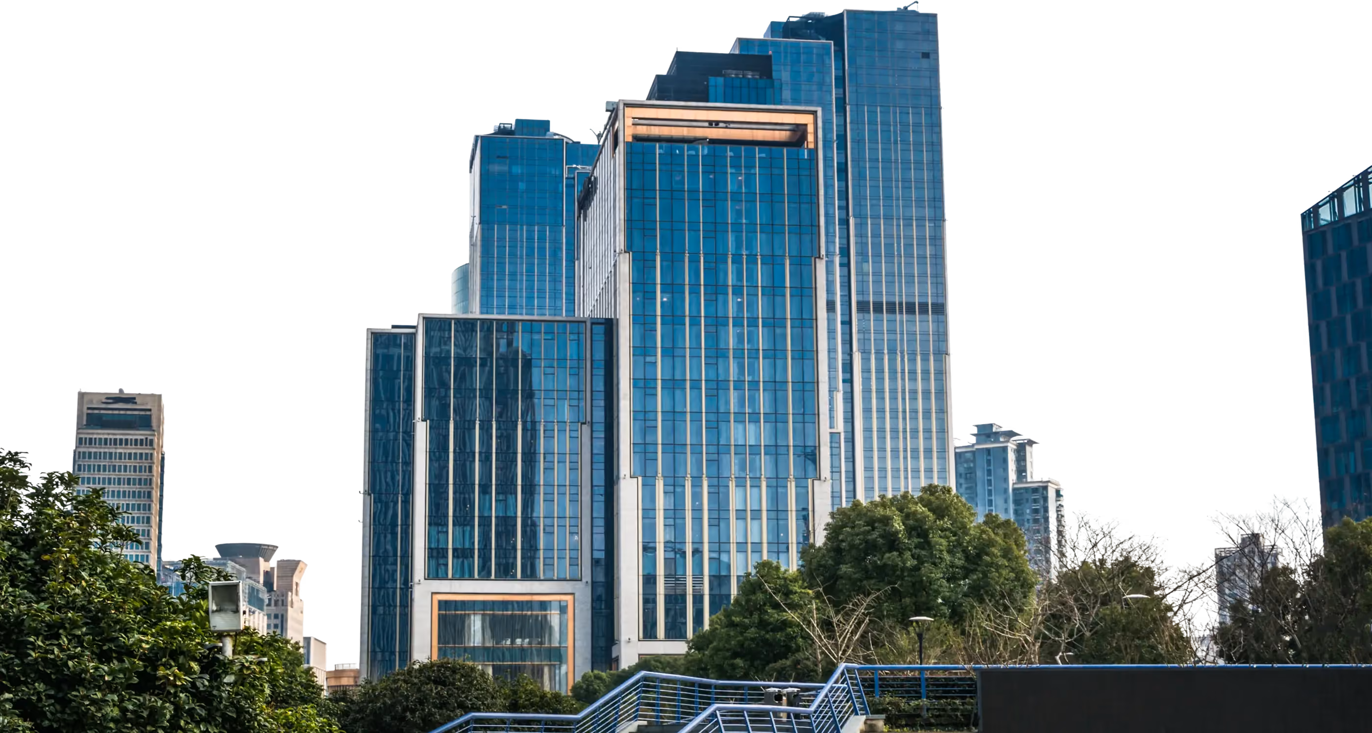 Modern glass office towers rising behind trees
