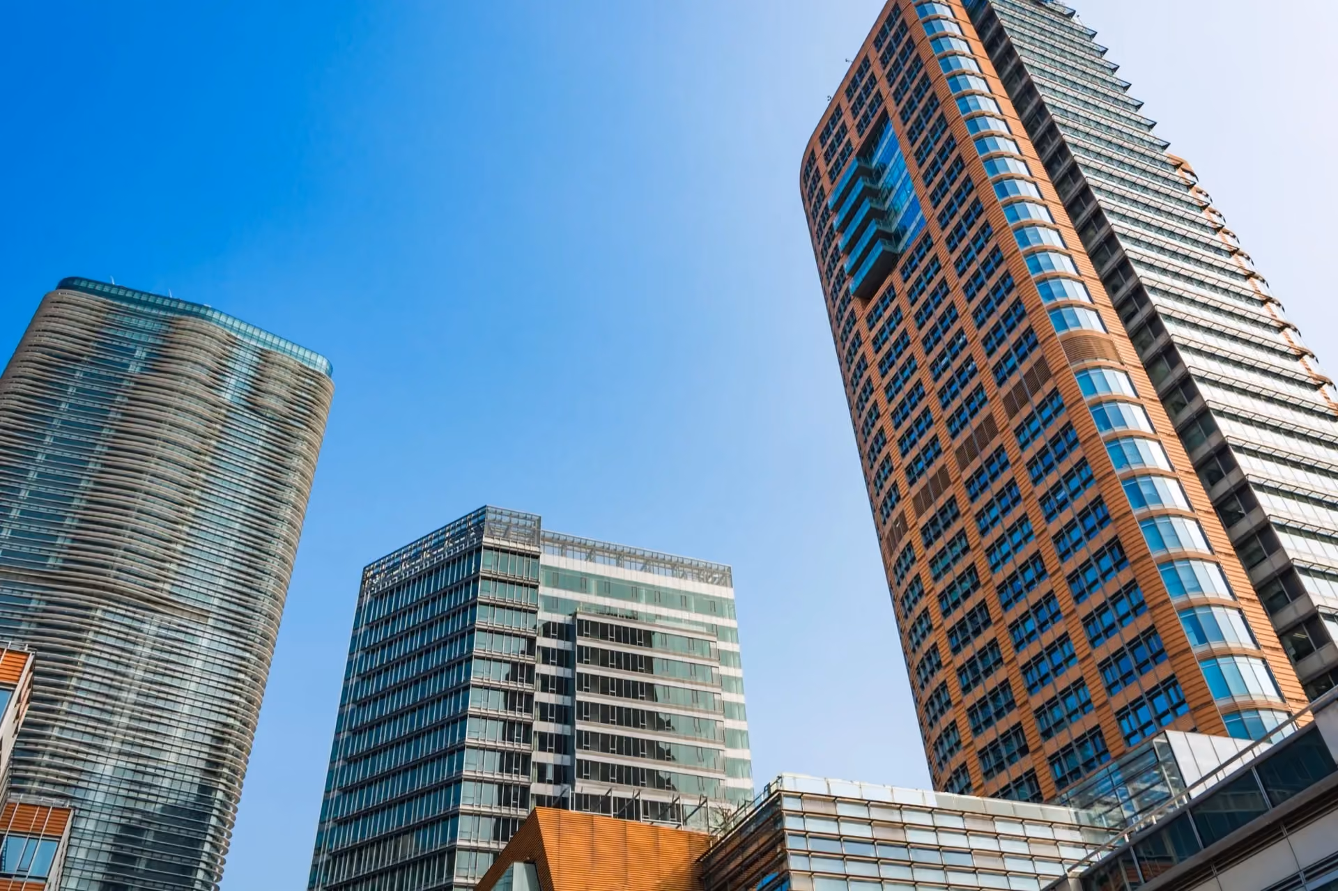 Glass and brick residential towers seen from below on a sunny day
