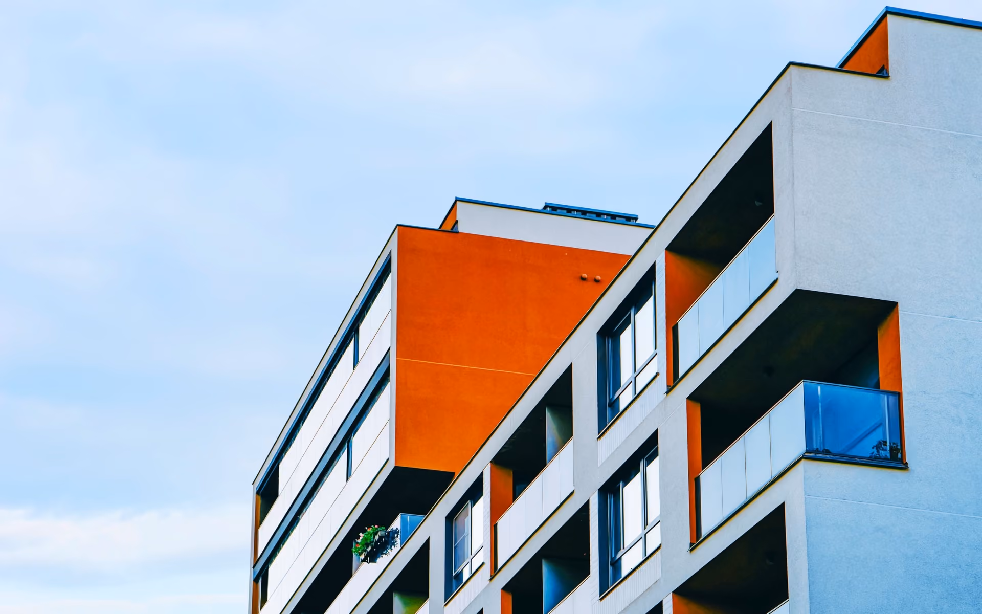 Blue and white modern apartment building on a quiet city street