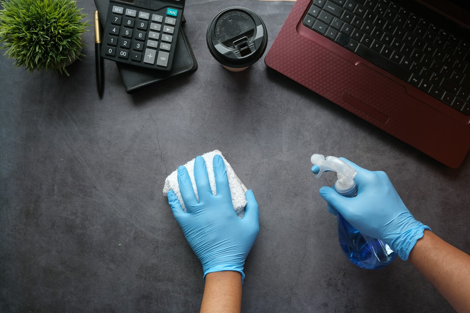 Agent de propreté nettoyant un poste de travail en soirée avec chiffon microfibre