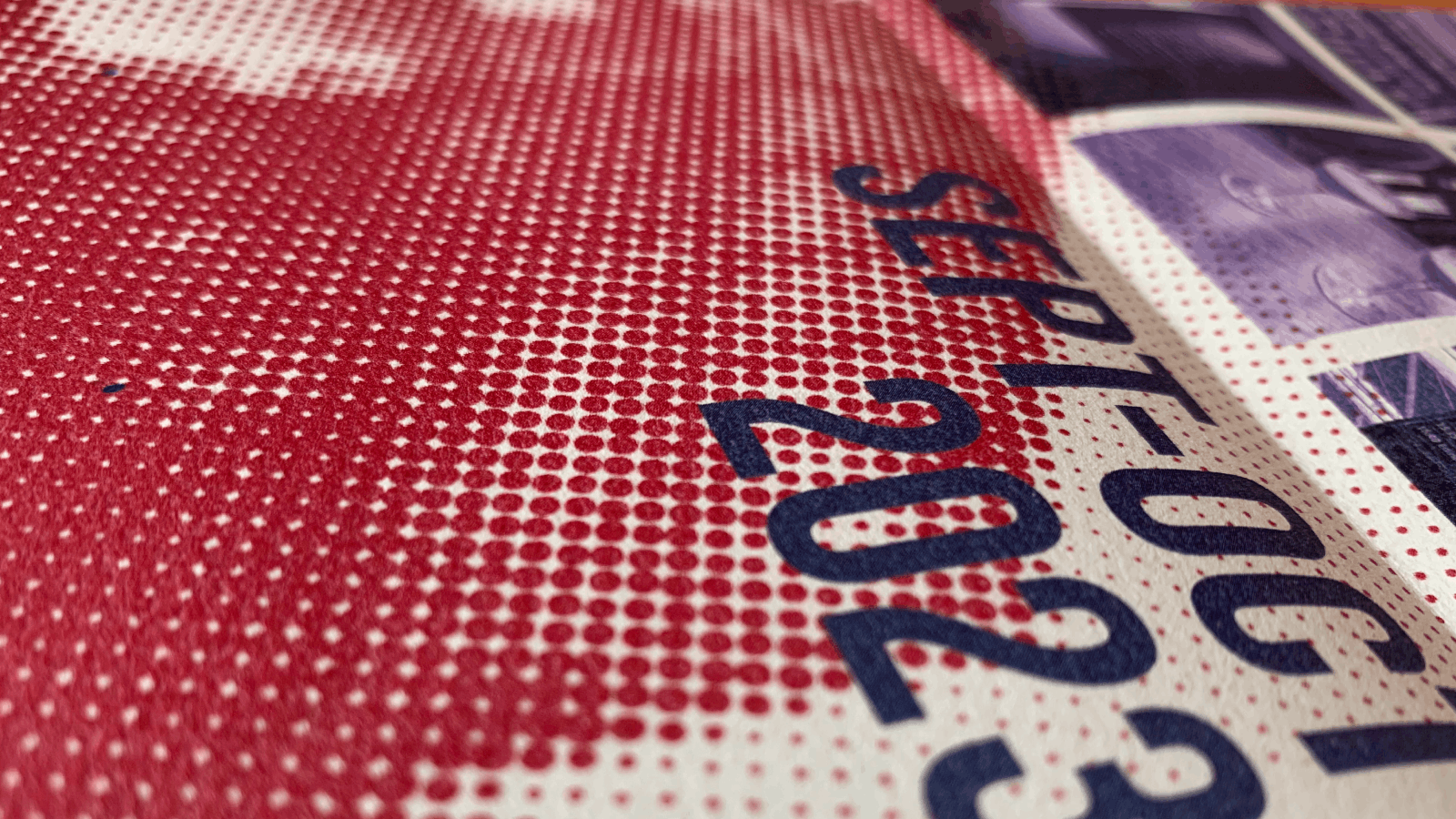 Close-up photo of a printed page showing a red halftone pattern and blue text reading 'SEPT- OCT 2023' on a white background.