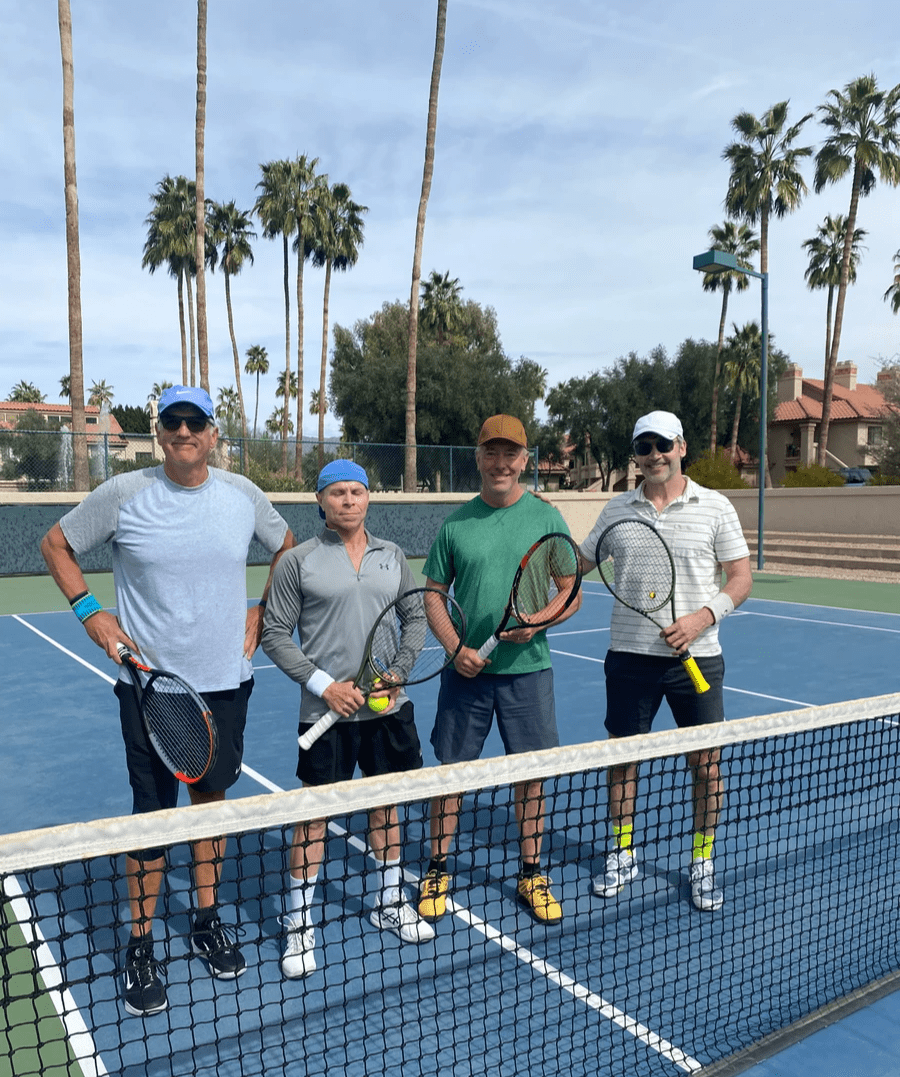 Four players with racquets standing behind the net at the 2024 doubles championship.