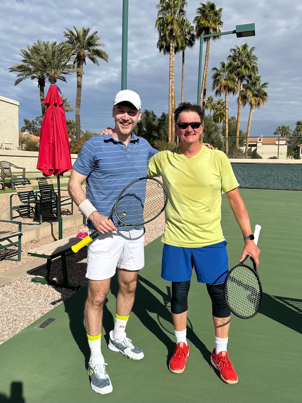 Two players with racquets standing beside the court at the 2024 singles championship.