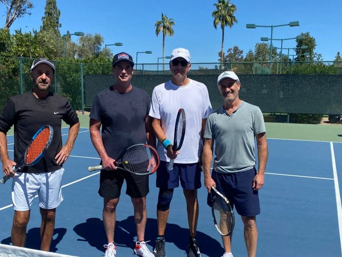 Four players with racquets on court at the 2024 Member/Guest tournament.