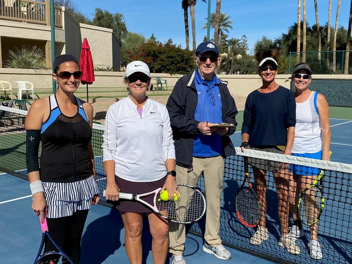 Players and an event participant gathered at the net after the 2022 ladies open final.