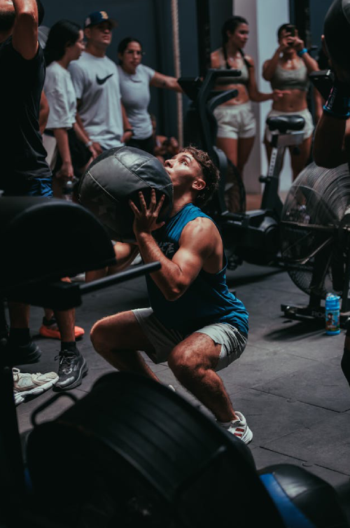 Athlete performing a medicine ball squat during a group workout at The Strength Yard in West Palm Beach, FL.