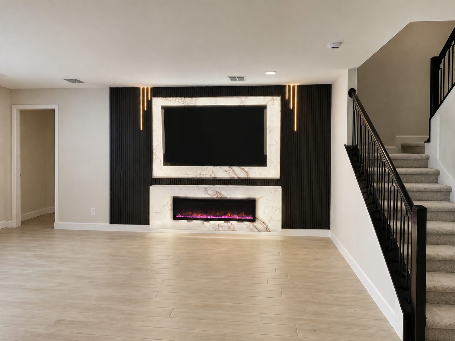 Custom media wall with black slat paneling and marble TV surround