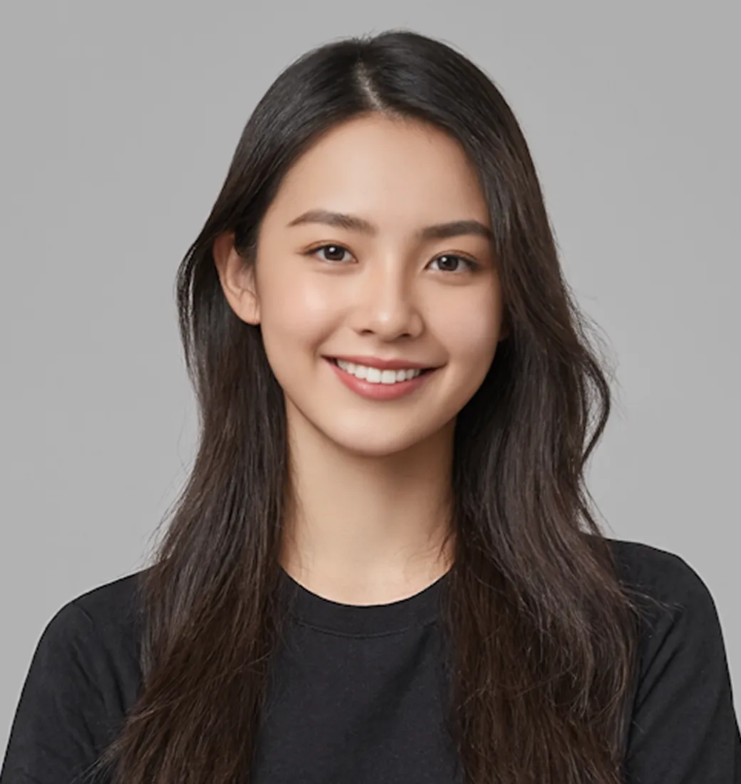 Young woman with long dark hair smiling and wearing a black shirt against a plain gray background.