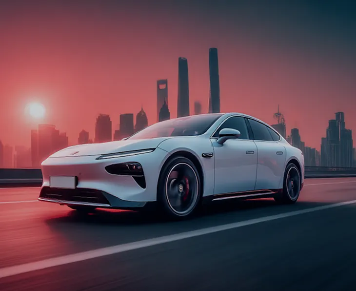 White sleek electric car driving on a city road at sunset with a skyline of modern skyscrapers in the background.