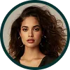Portrait of a woman with curly brown hair, wearing hoop earrings and a dark top, with a neutral facial expression.