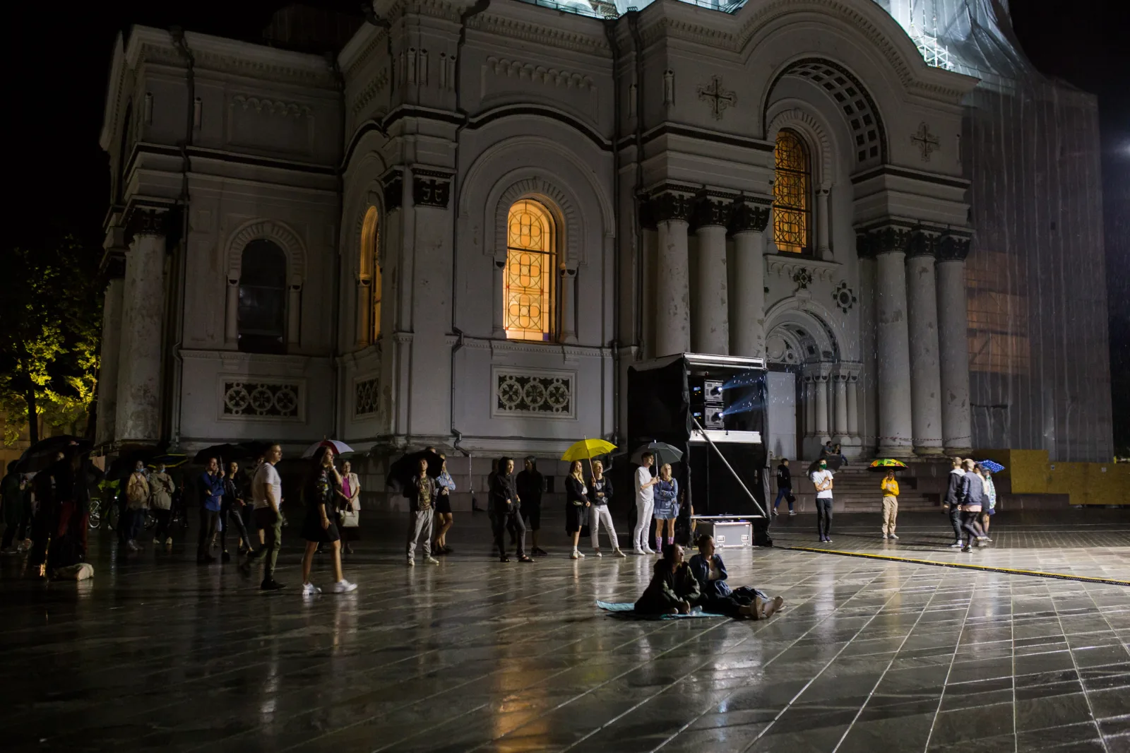 #Protest – spectators gather in a wet square in front of a lit church