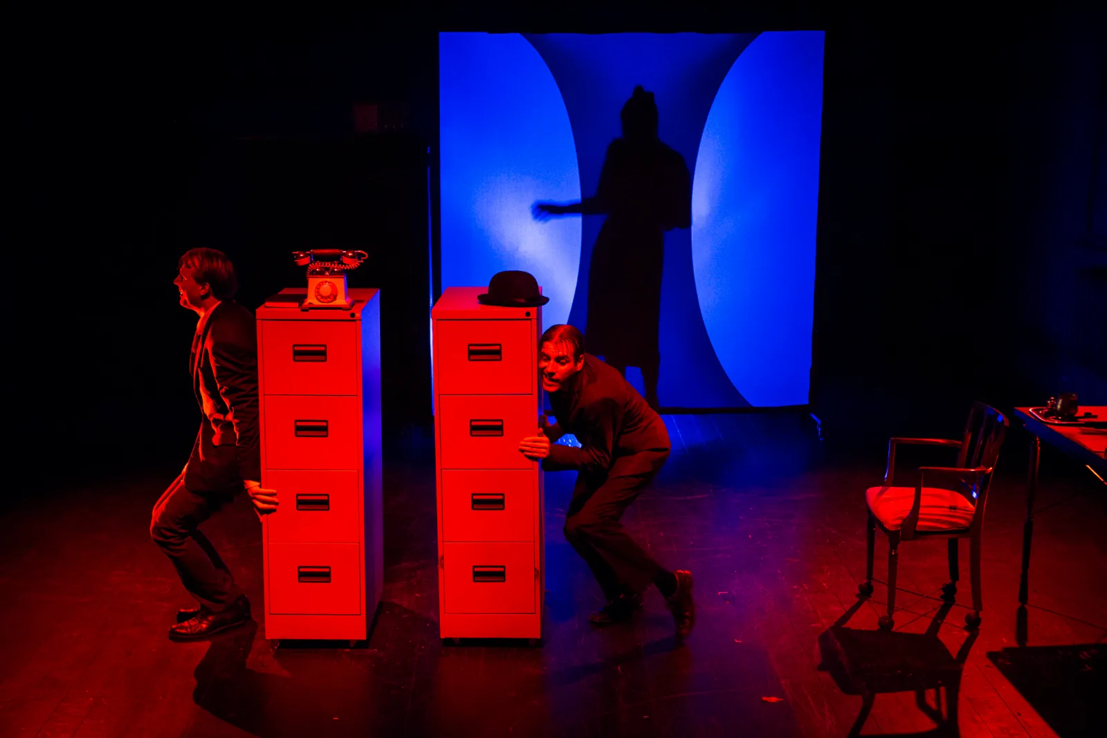 Kafka Insomnia – two actors hide behind filing cabinets on a stage