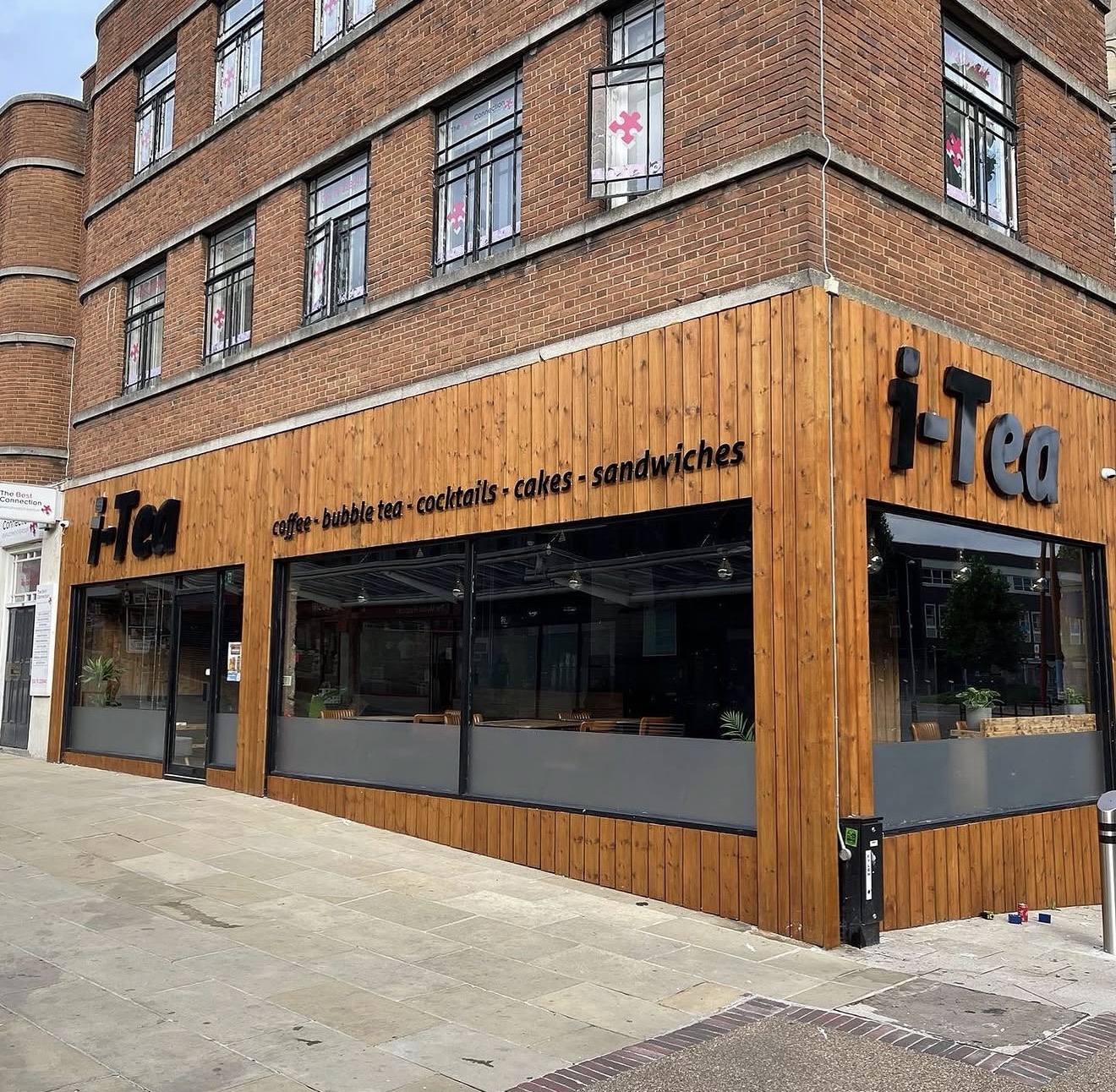iTea exterior fascia signage installed on a timber-clad storefront.