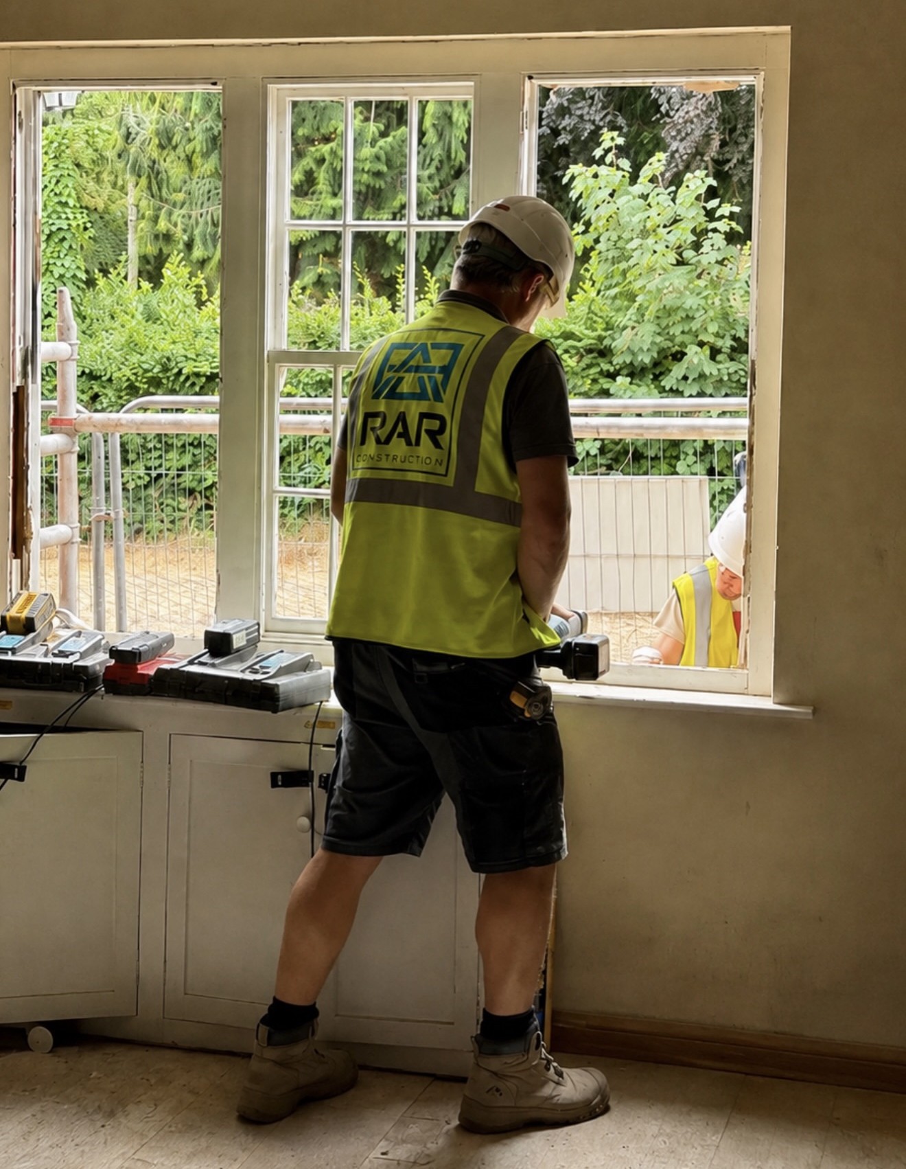 RAR Construction worker on site beside a newly fitted window.
