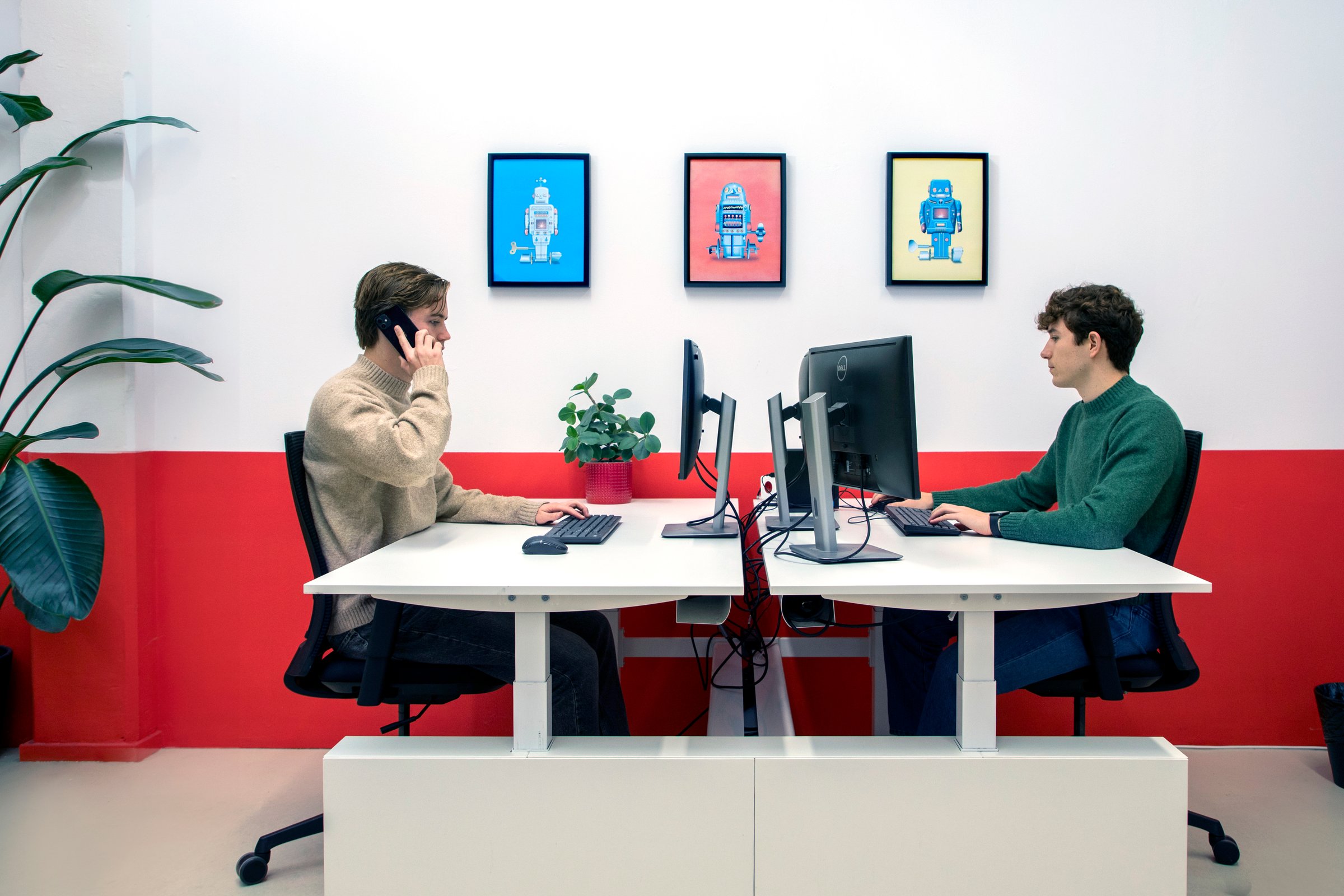Twee VionA-collega's aan het werk aan tegenover elkaar staande bureaus