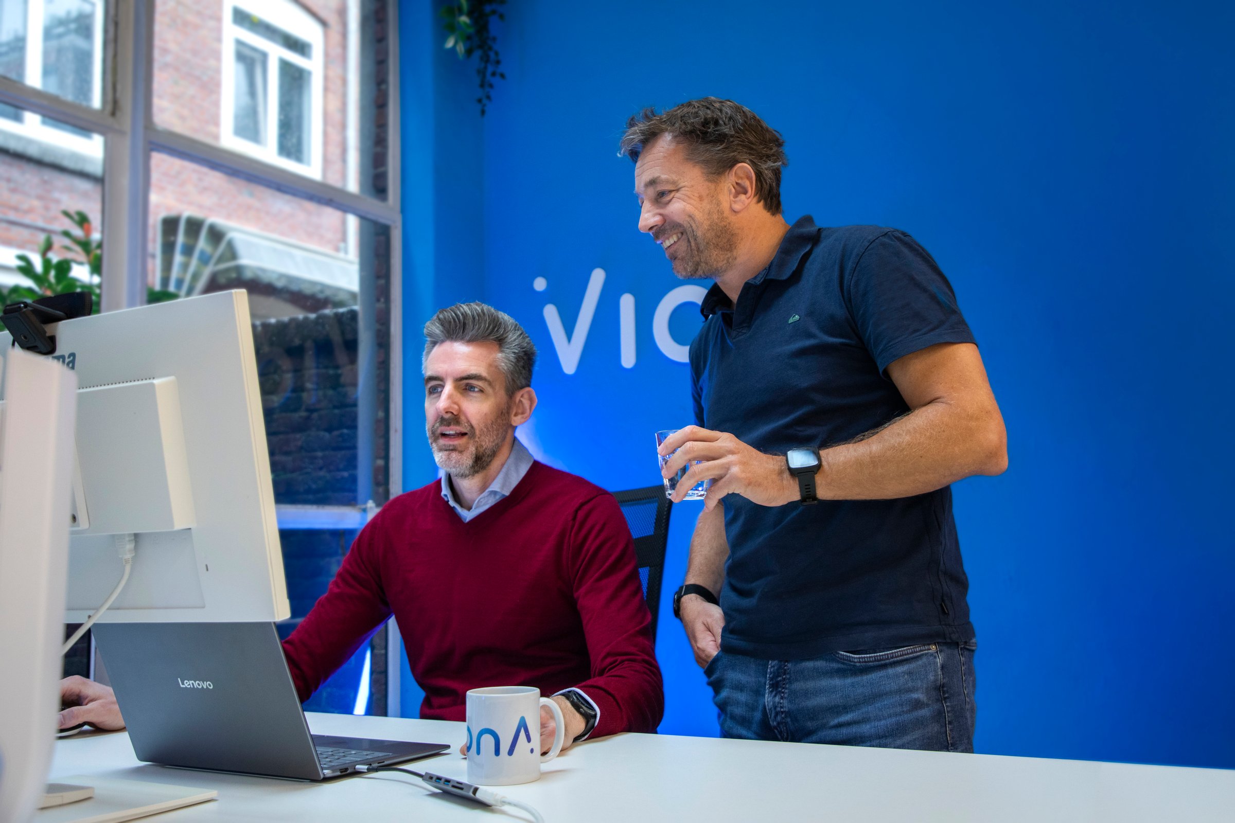 Two VionA colleagues looking at something on a screen together