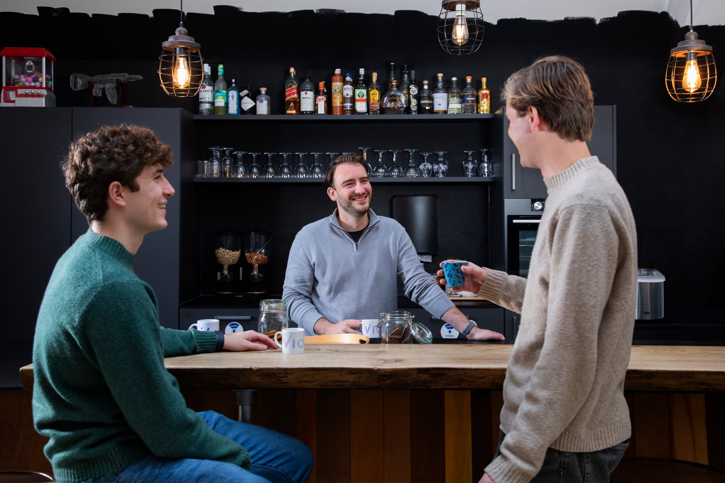 Drie VionA-collega's in gesprek aan de bar op kantoor