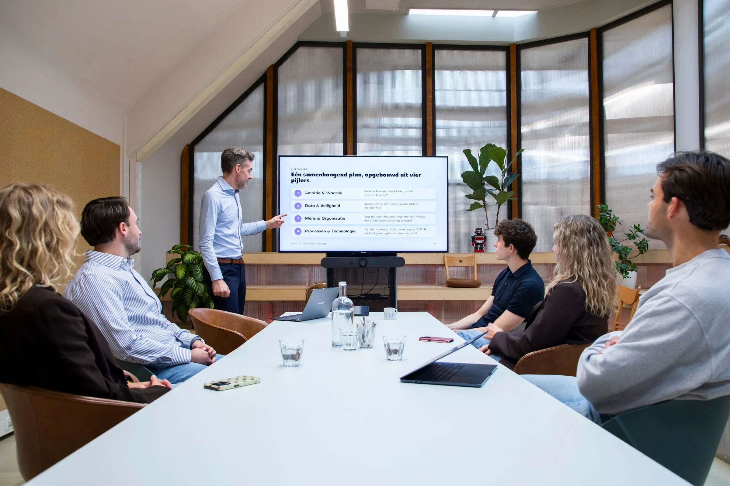 VionA licht de vier pijlers van een AI-strategie toe aan een team rond de vergadertafel