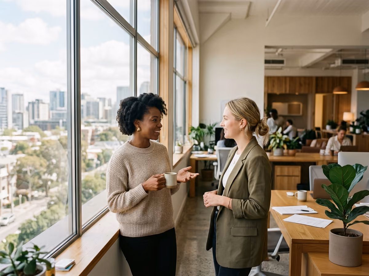 Two colleagues talking at a desk during a working session