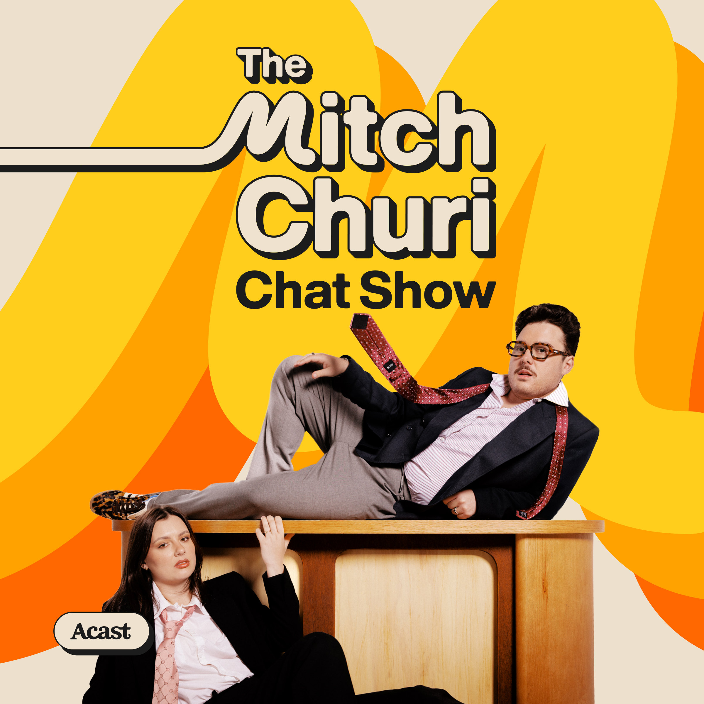 Episode art: Mitch lounging on a wooden desk, a guest sitting below
