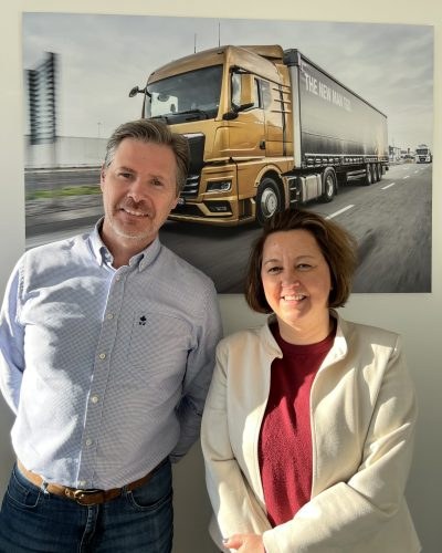 Twee medewerkers van MAN Belgium voor een foto van een MAN-vrachtwagen