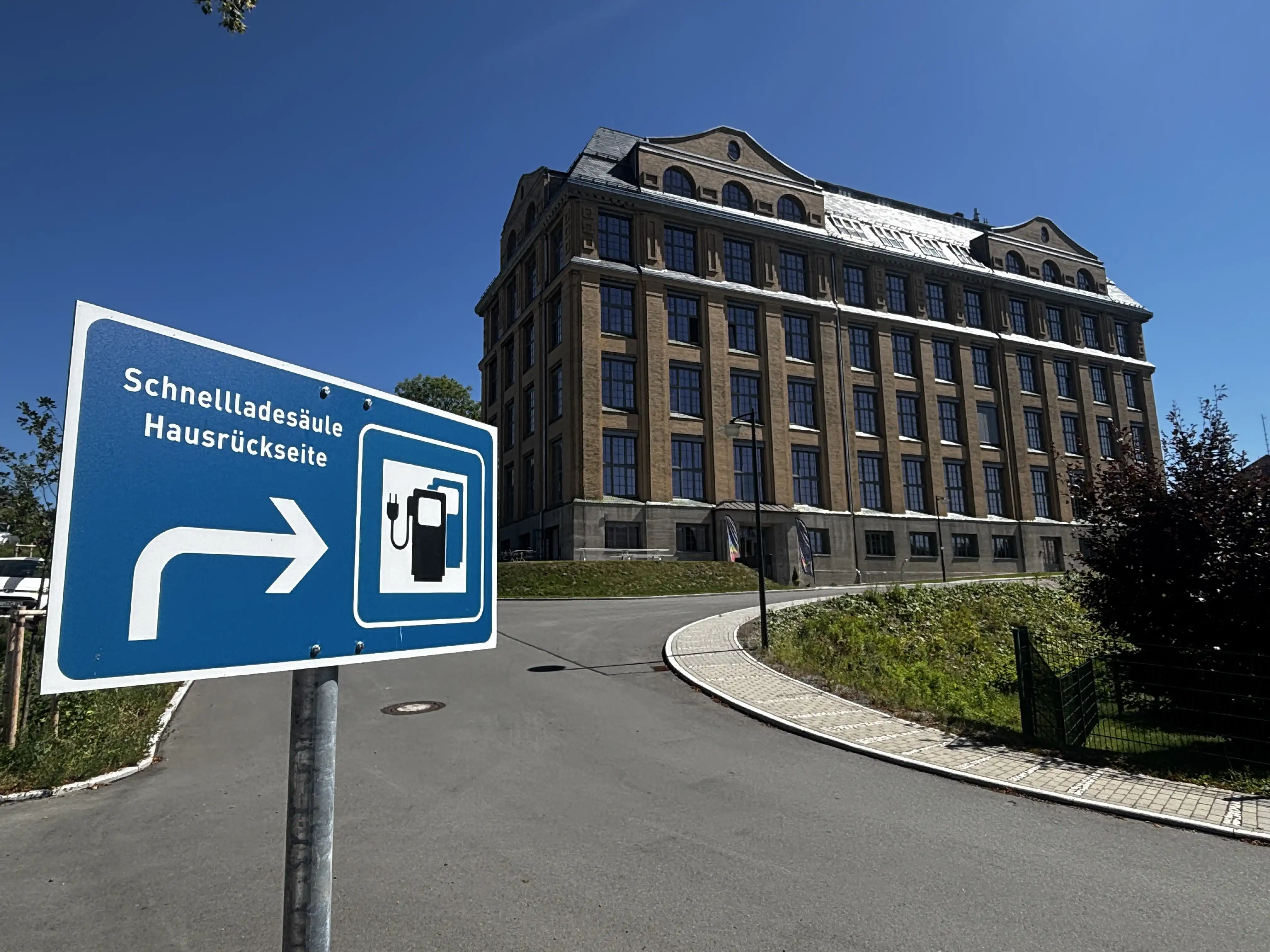 Wegweiser zur Schnellladesäule an der Rückseite des Buntspeichers