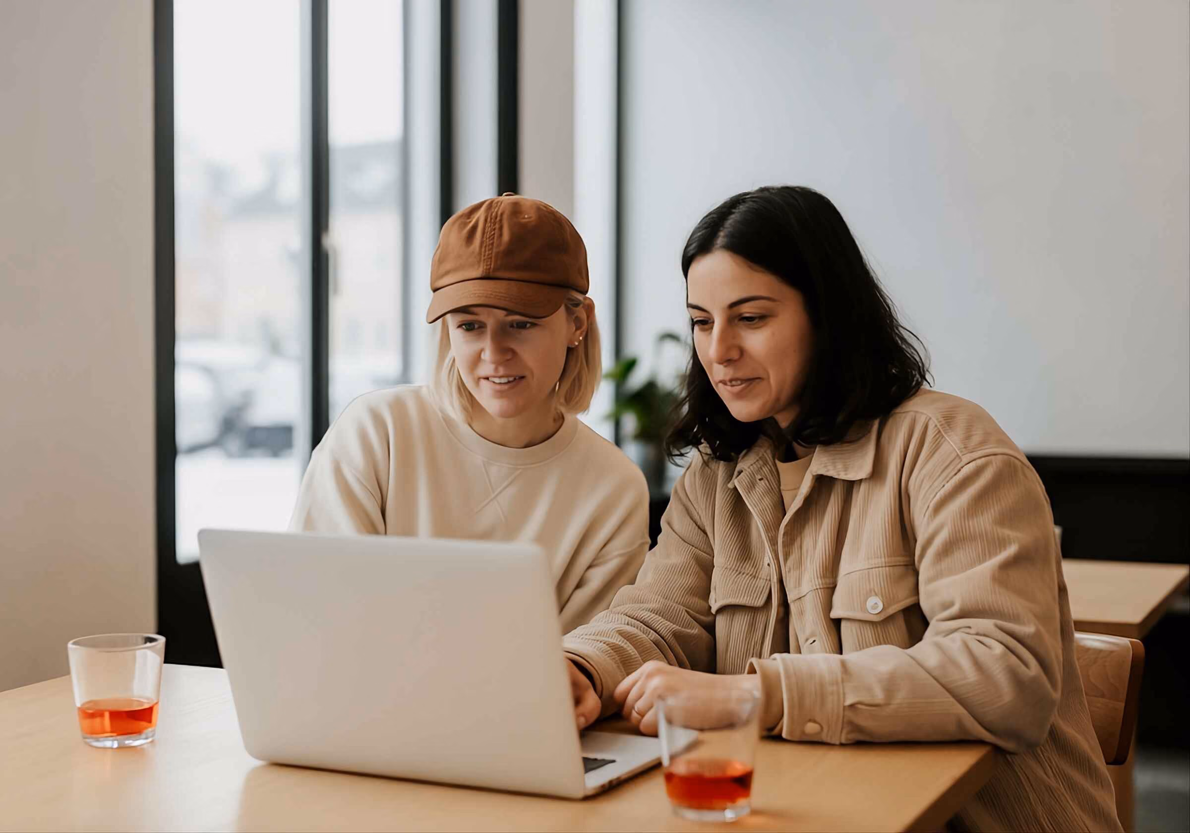 Two business professionals discussing a project while sharing a laptop screen.