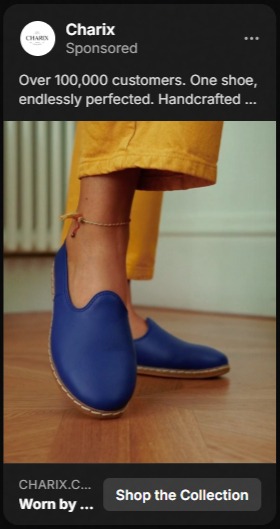 Close-up of a person wearing bright blue slip-on shoes with a natural sole, paired with mustard yellow pants, standing on a wooden floor.