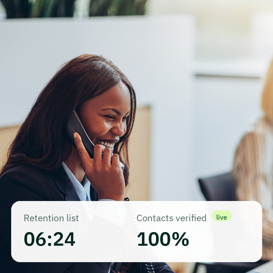 Smiling woman in a business suit talking on a phone in an office environment, with an overlaid box showing retention list time 06:24 and contacts verified 100% with a live status indicator.