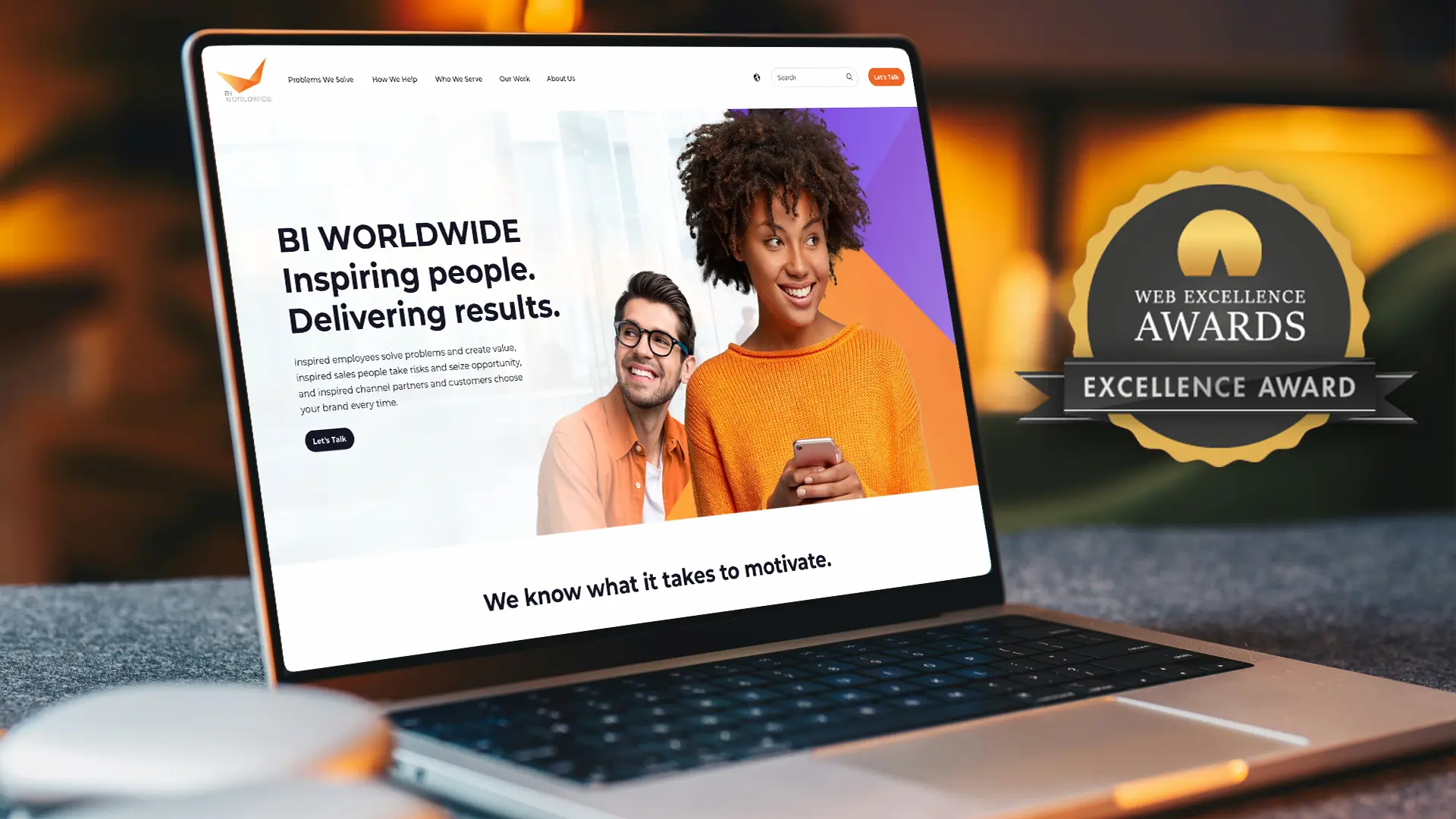 A laptop displays a website with the text BI WORLDWIDE Inspiring people. Delivering results. Next to two smiling people. To the right, a Web Excellence Awards badge is visible.