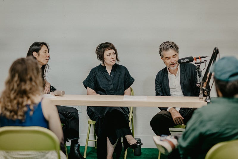 Joon Lee, Tracy Steepy, and Roddy Schrock, onstage with microphones in the beginning of the public conversation.