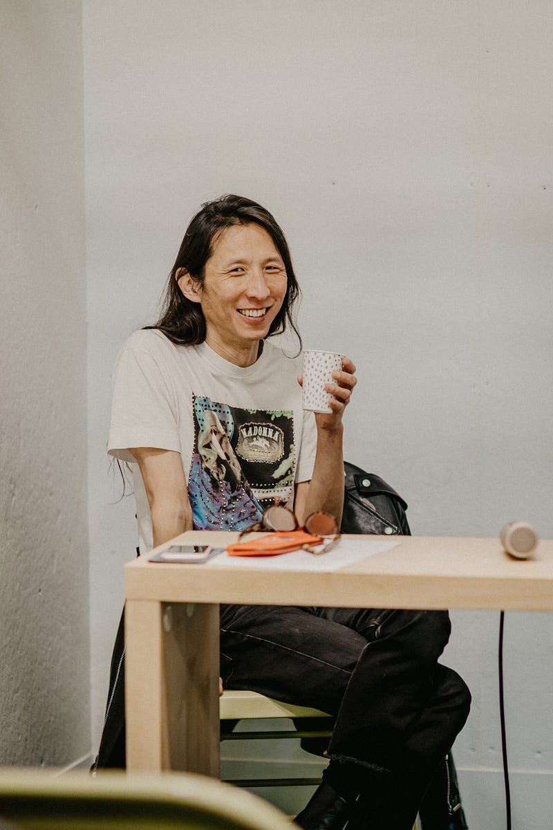 Candid shot before the conversation of Joon Lee with a glass of homemade apple cider.