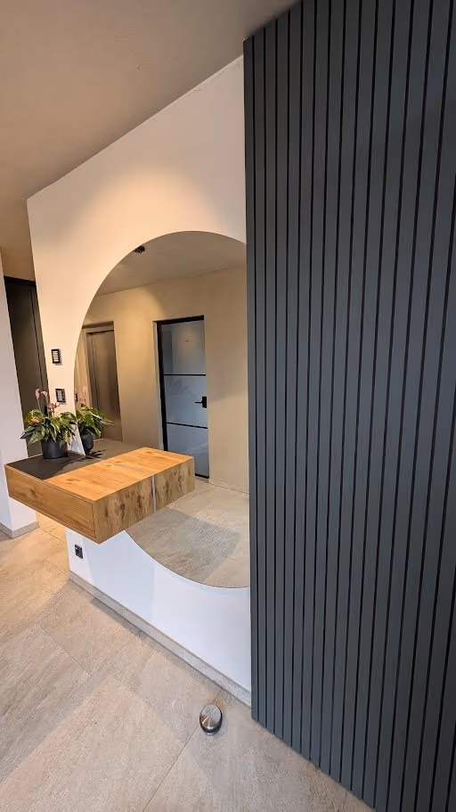 Wandverkleidung aus dunklen Holzlamellen mit Rundbogen