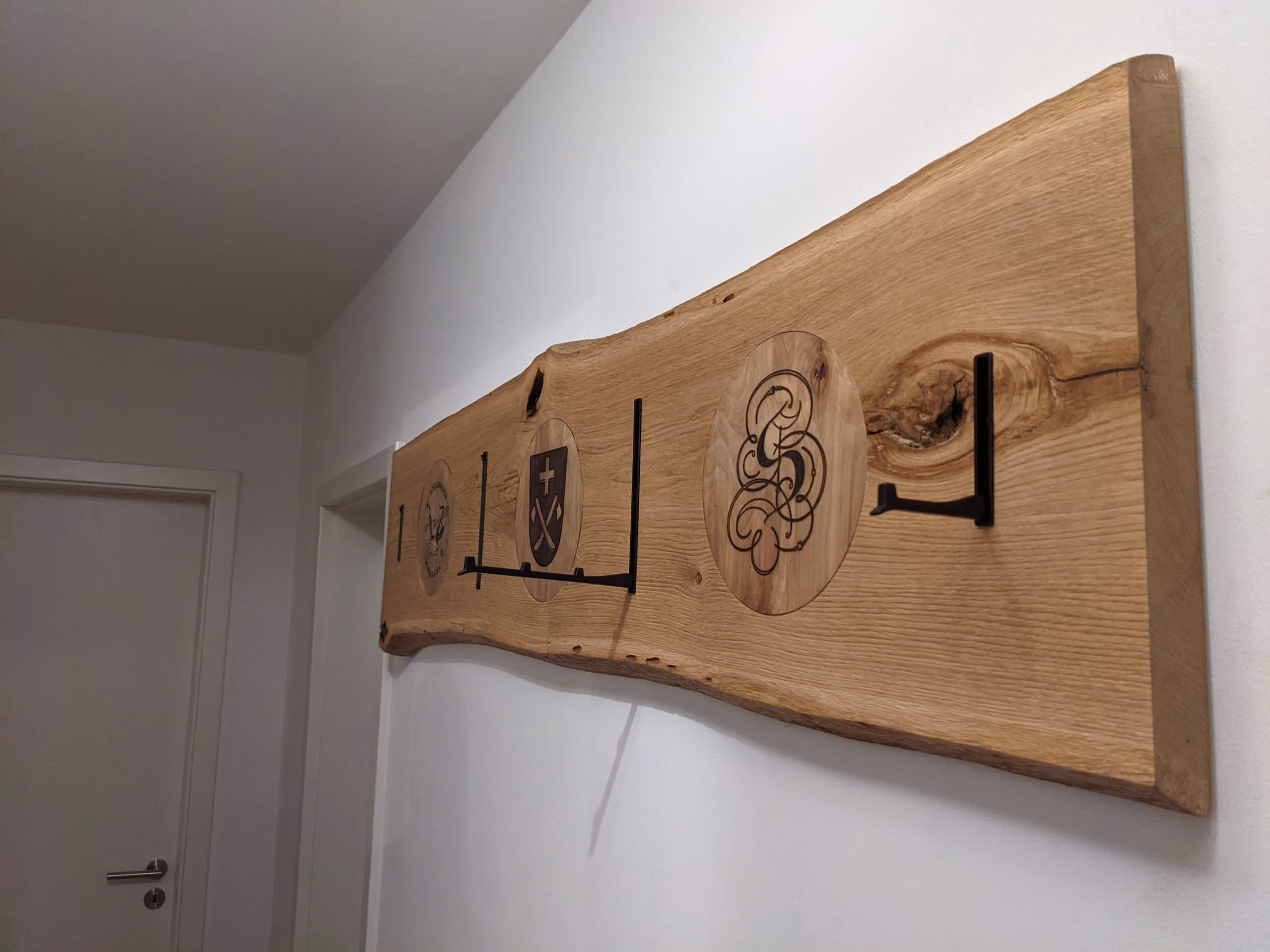 Wandgarderobe aus einer Eichenbohle mit Schnitzdetail