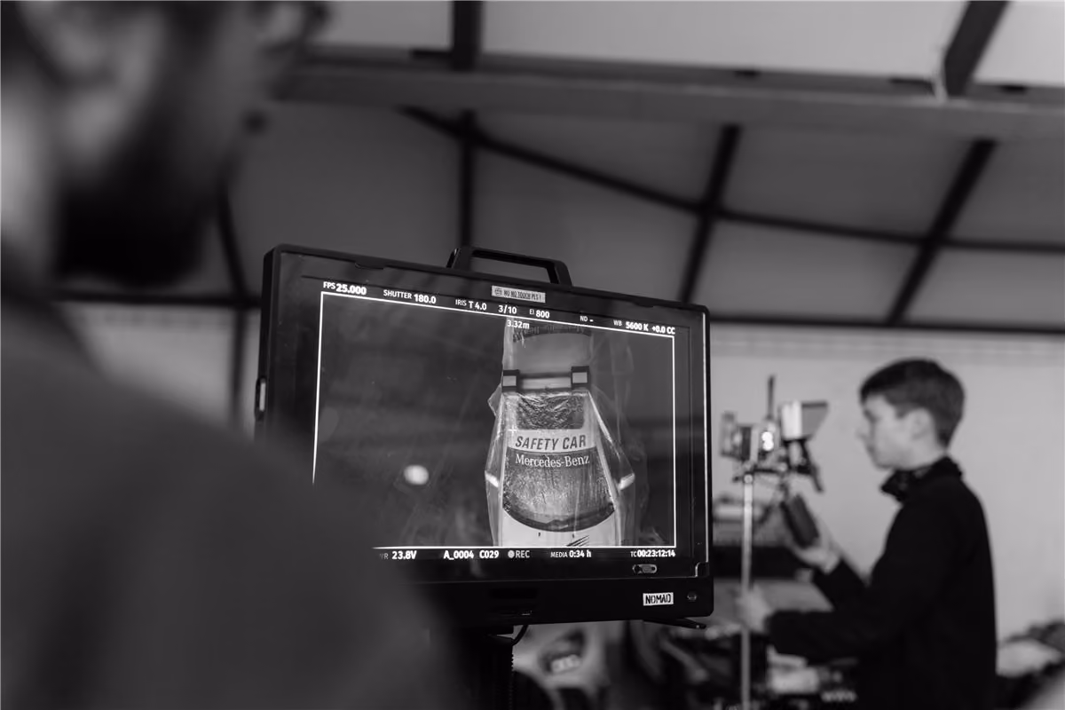 Camera operator checking a car shot on a field monitor