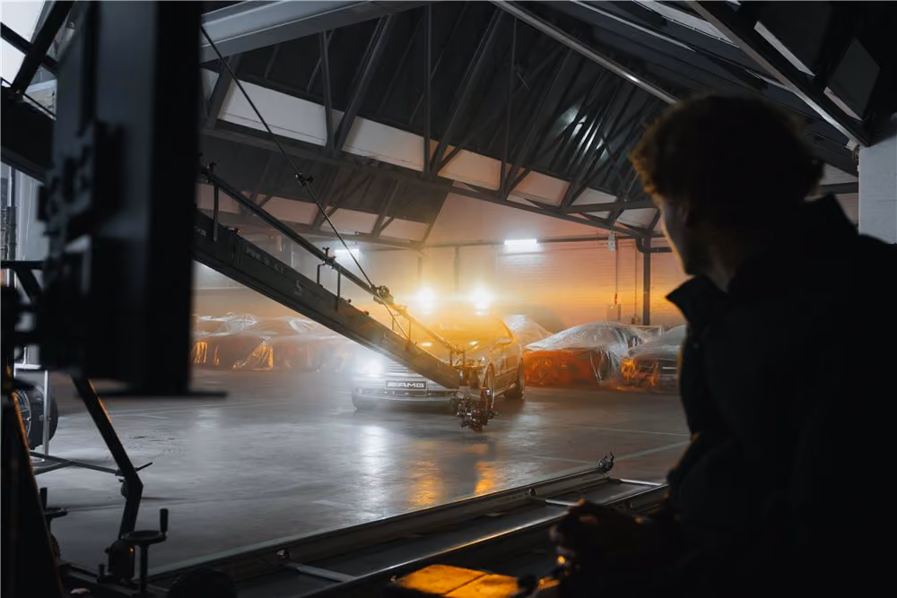 Crew member watching a camera crane shot in a foggy hangar