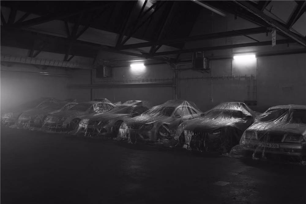 Covered cars lined up in a hangar before the shoot